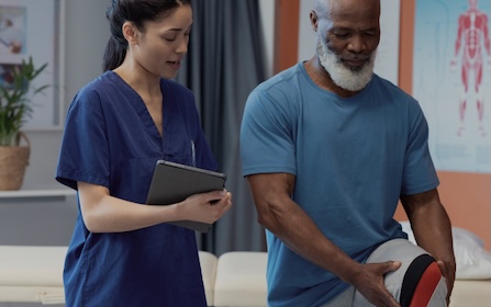 Therapist assisting a patient with leg exercises during a rehab session